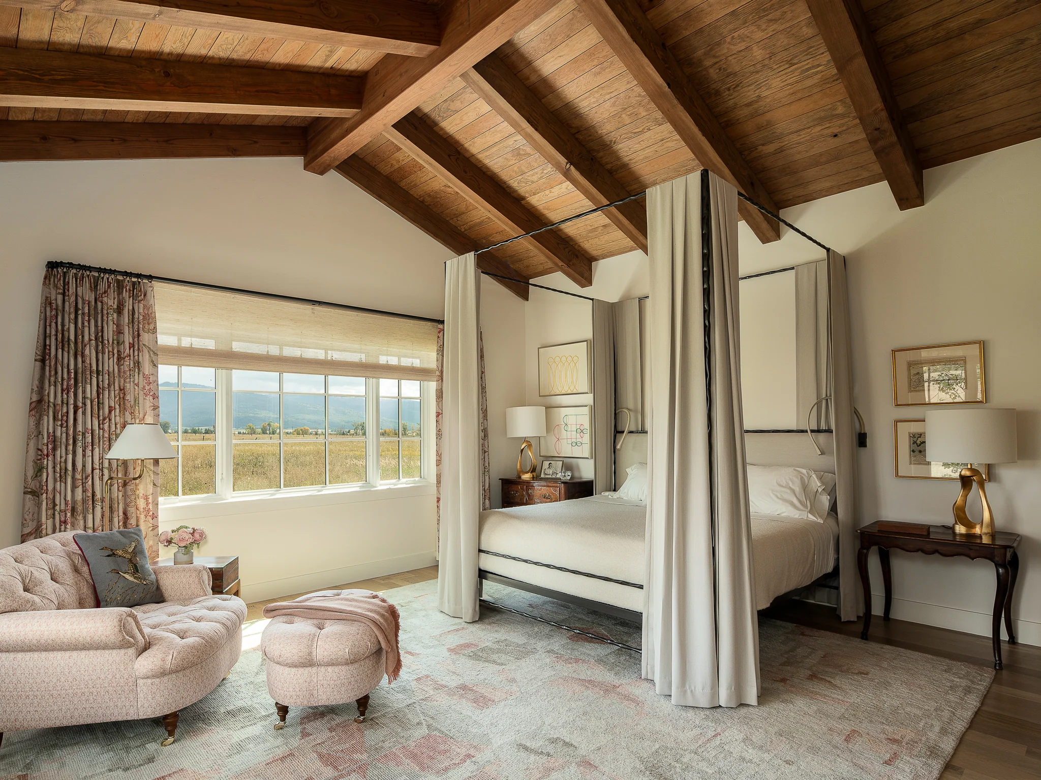 Primary bedroom with a canopy bed beneath a vaulted wood ceiling and valley views — interior design photography Driggs Idaho, River's Edge